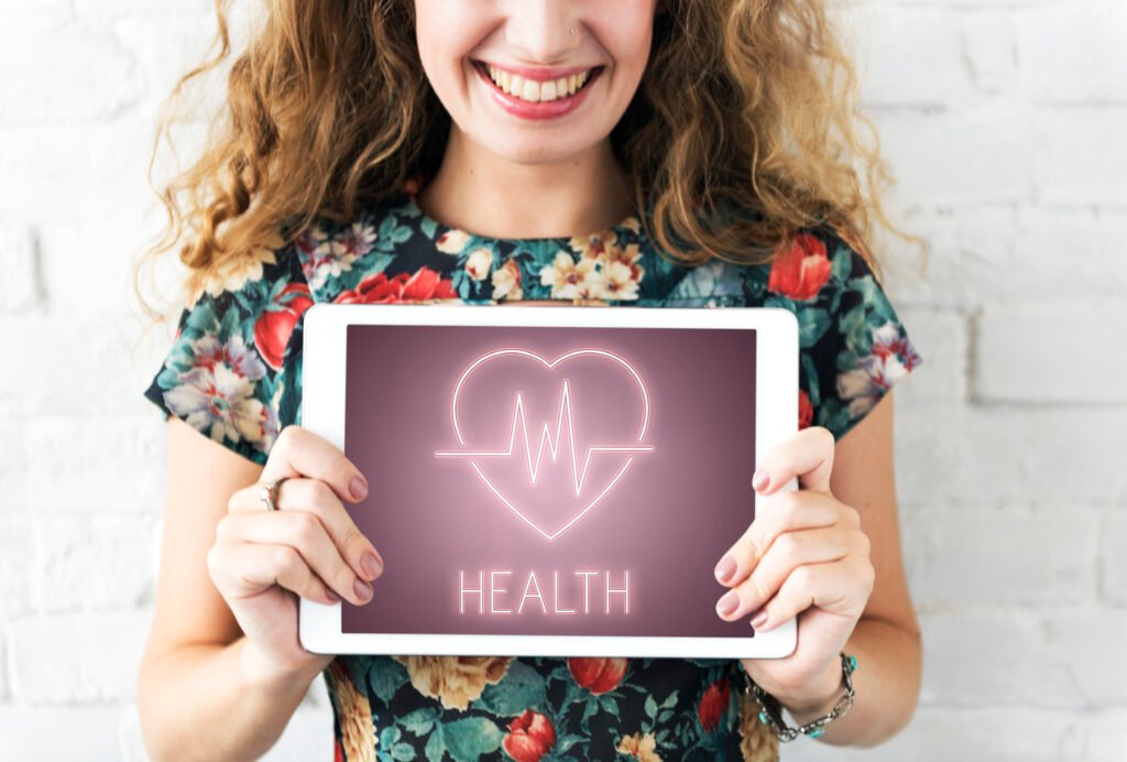 Smiling women shows a heartbeat signal on a tablet