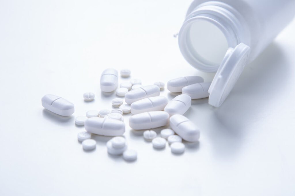 Spilled pill bottle with tablets scattered on a surface, illustrating challenges with supplement absorption and effectiveness.