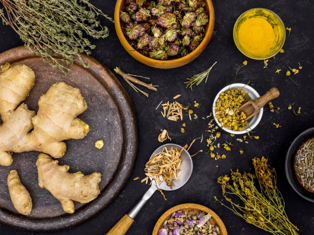 Medicinal herbs and spices including ginger, turmeric, and chamomile, displayed on a natural background.